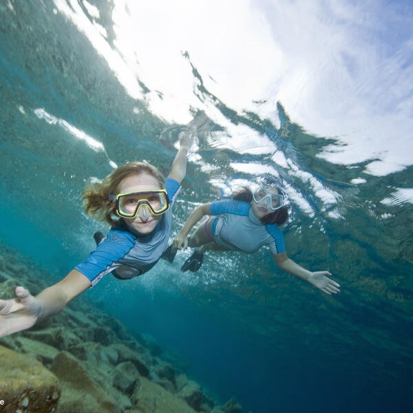 Zwei Kinder schnorcheln im Flachwasser über Felsen im Meer, Kroatien